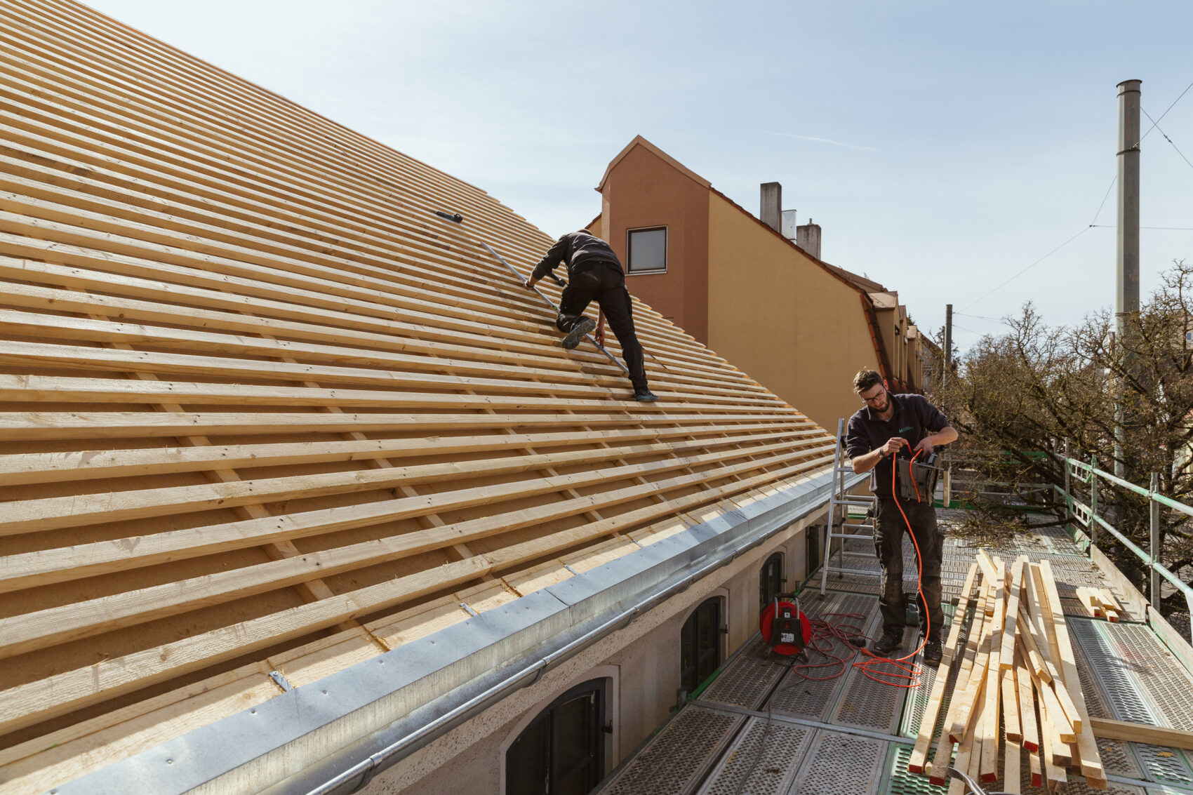 Ein Zimmerer von Holzbau Hillebrand auf einem halbfertigen Dach