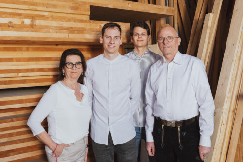 Die Familie Hillebrand vor einem Stapel Holz