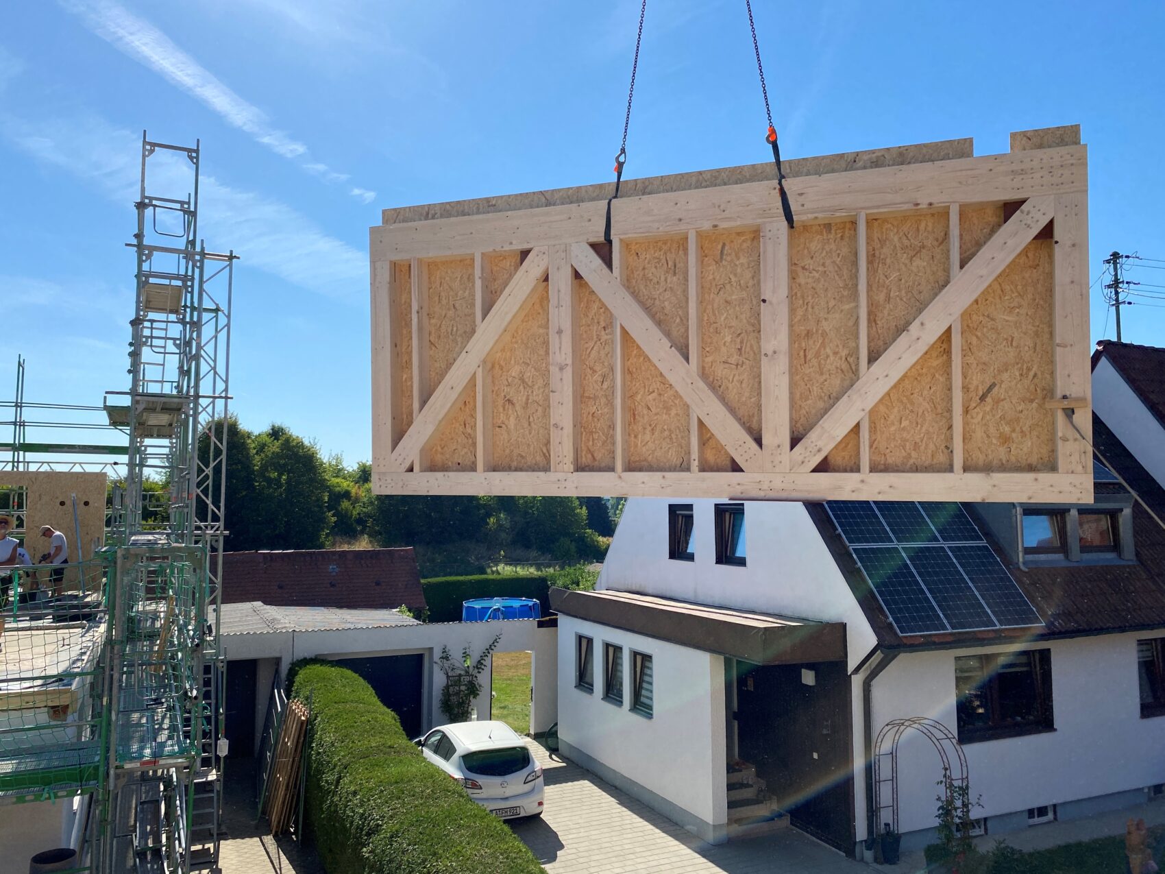 Ein Holzbauteil hängt an einem Kran